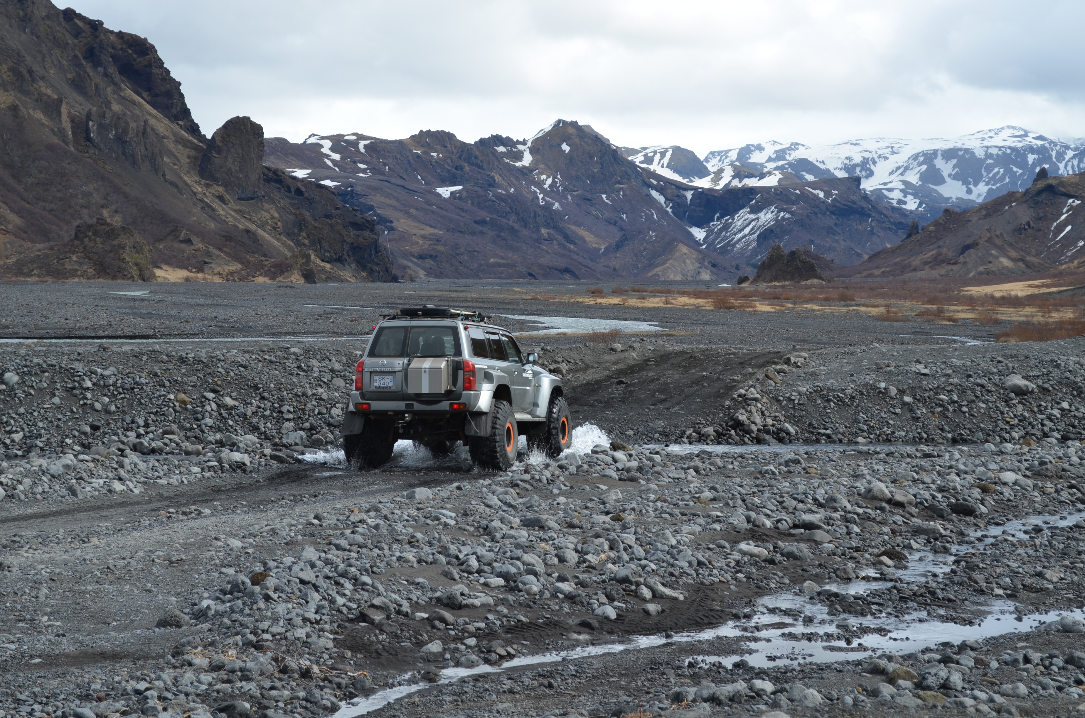 Ein jeep fährt durch eine kleine Furt im Hochland von Island, Thorsmörk