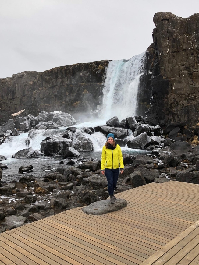 Wanderin vor dem Wasserfall Öxarafoss in Islands Nationalpark Thingvellir