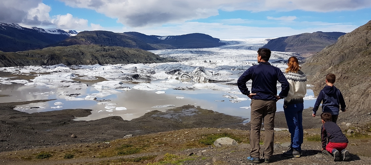 Familie schaut auf einen Gletscher in Island