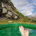 Füße schauen aus einem Hot Pot heraus in Südostisland