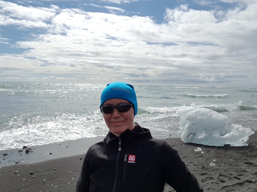 Eisblöcke am Strand bei der Gletscherlagune in Südostisland, Wanderin im Vordergrund